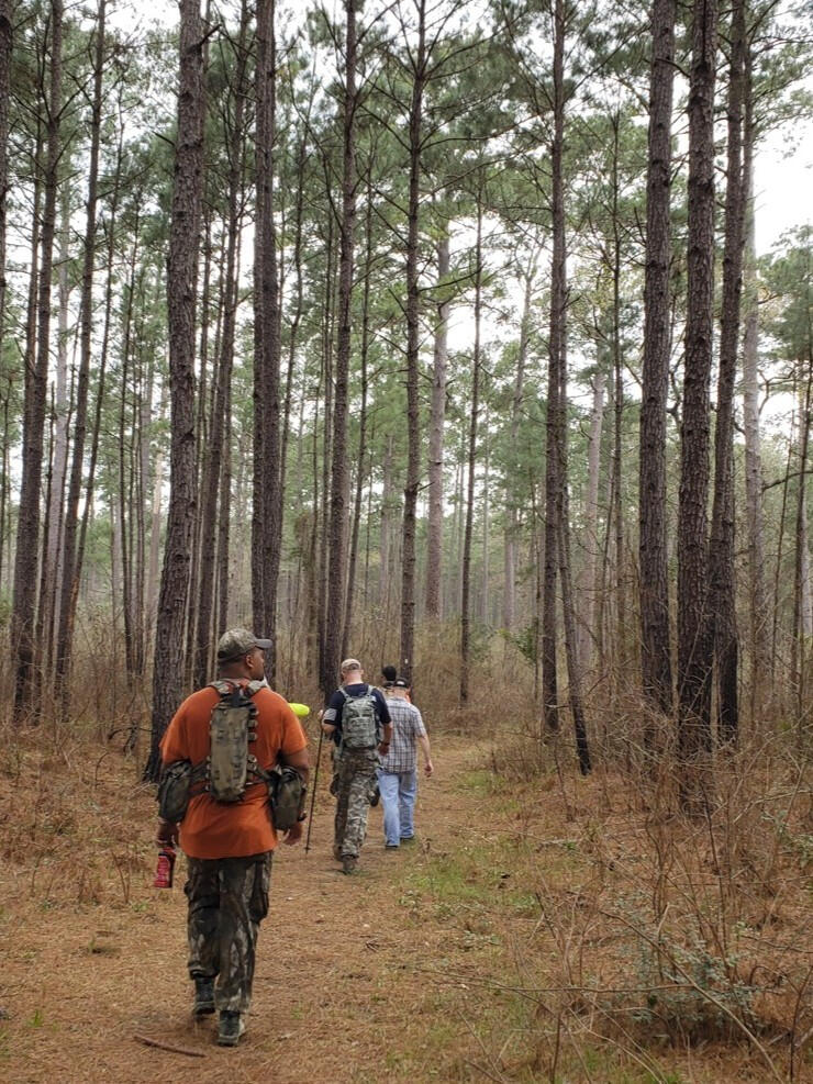 Smelling the Pines Men hiking through Houston National Forest during Christian men's retreat